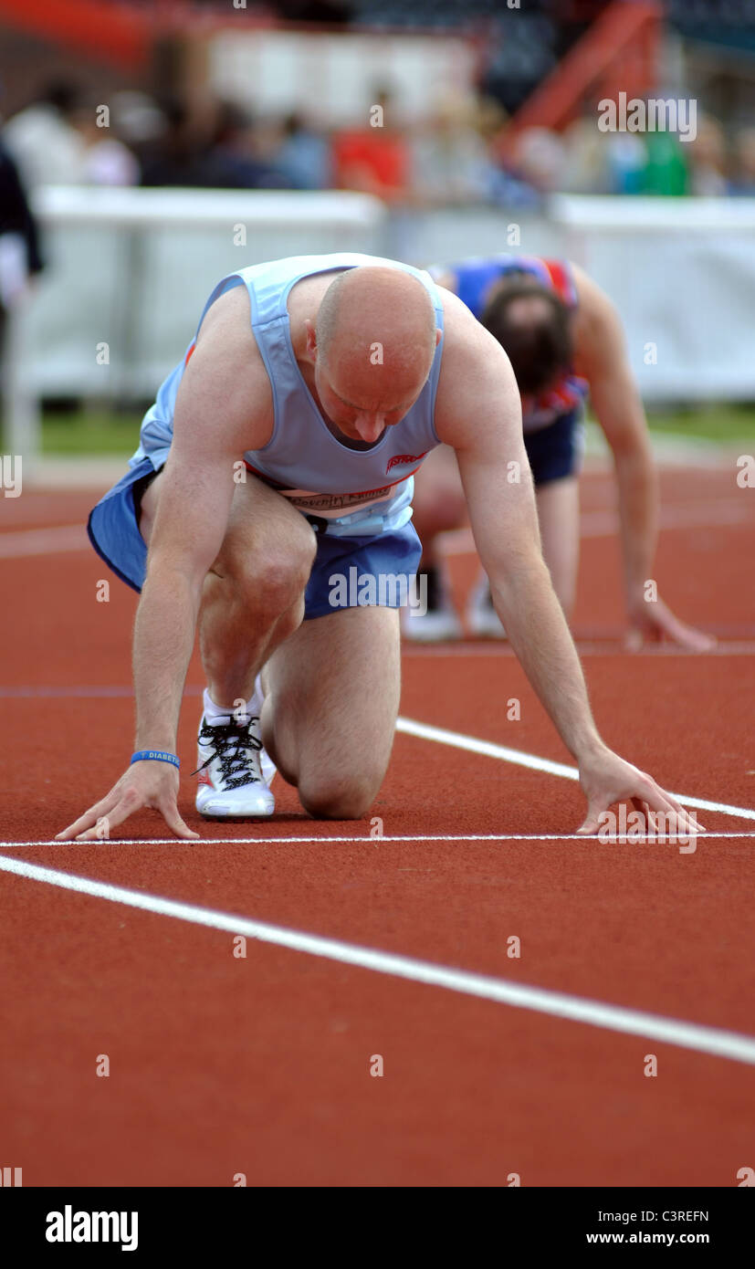 Runners at the start of a men`s 400m race Stock Photo